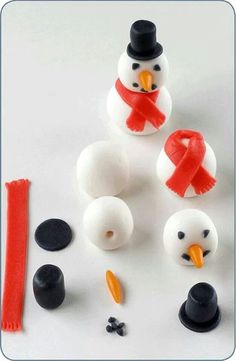 a snowman made out of marshmallows and other plastic items on a white surface