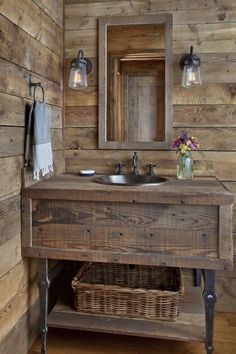 a rustic bathroom with wooden walls and wood flooring on the wall, along with an antique sink