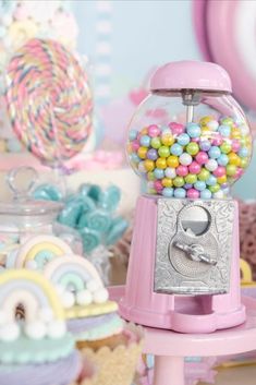 a pink gummy machine sitting on top of a table next to other candy items