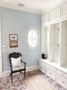 a chair sitting in the corner of a room next to a window and some drawers