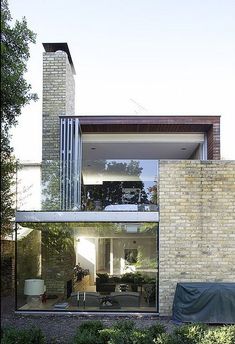 a brick building with a covered patio in the foreground and an outdoor living area on the other side