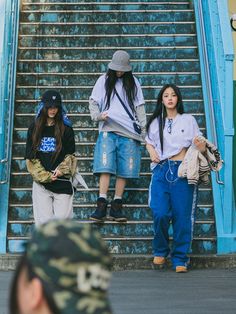 three young people are walking up some stairs