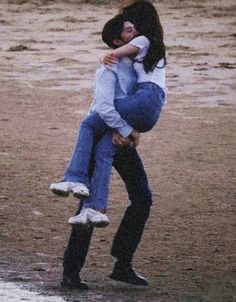 two people are hugging each other on the beach