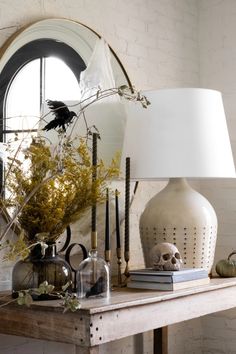 a table topped with a lamp next to a mirror