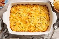 a casserole dish with cheese on top and other dishes in the back ground