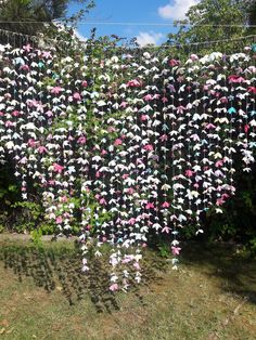 there are many paper cranes hanging from the line in the yard with string attached to it