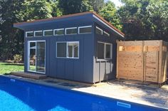 a backyard shed next to a swimming pool