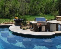 a pool with an outdoor kitchen and grill in the back yard next to it is instagramted for pinterest