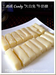 three pieces of cheese on a white plate with chinese writing in the background and an image of milk candy