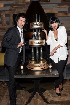 two people standing in front of a cake