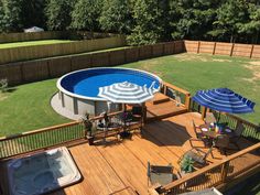 an above ground pool surrounded by decking and patio furniture with umbrellas over it