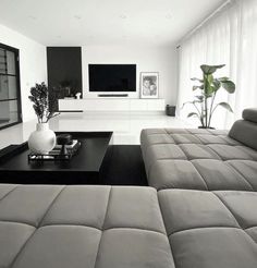 a living room filled with furniture and a flat screen tv mounted on the wall above it