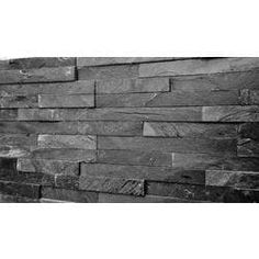 a black and white photo of a wall made out of slate tiles, with the top section missing