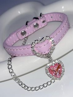 a pink heart charm bracelet on top of a white toilet