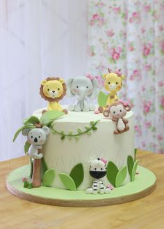 a cake decorated with animals on top of a wooden table