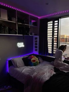 a woman sitting on top of a bed in a bedroom next to a large window