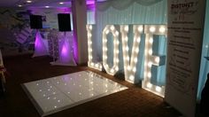 a dance floor with lights on it and the word love spelled out in white letters