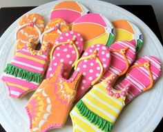 decorated cookies are arranged on a plate with shoes and flip flops in the middle