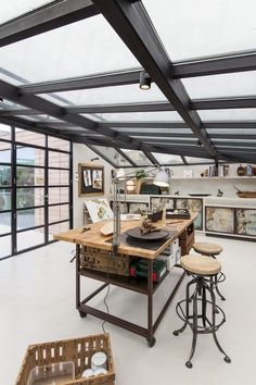 an industrial kitchen with lots of counter space and stools in front of the island