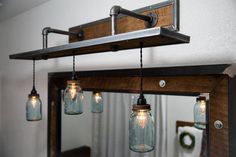 mason jar lights are hanging from the ceiling in front of a mirror and light fixture