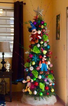 a brightly colored christmas tree with mickey mouse ornaments