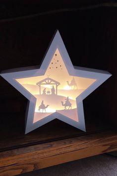 a lighted star with nativity scene on it