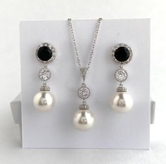 I've created this elegant black cubic zirconia and pearl bridal  jewelry set in rhodium plated brass setting and the set includes: # Earrings feature large 12mm Austrian crystal pearls that dangle from brilliant cut black cubic zirconia with halo setting 12mm ear stud and round     cubic zirconia connector. Halo setting gives a brilliantly beautiful effect. Total length of the earrings is 3.8 cm.  #Classic pearl bridal necklace and pendant set with rhodium plated and bail and round cubic zirconi Black Crystal Jewelry Sets For Wedding, Elegant Black Jewelry Set For Wedding, Black Sterling Silver Jewelry With Pearl Drop, Formal Black Round Jewelry Sets, Formal Black Jewelry With Pearl Pendant, Formal Black Pearl Pendant Jewelry, Black Pearl Drop Jewelry For Anniversary, Rose Gold Bridesmaid Jewelry, Pearl Wedding Jewelry Sets