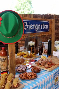 a table topped with lots of different types of food next to a sign that says biergarten