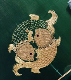 two gold fish with red eyes on a green surface in the shape of a net