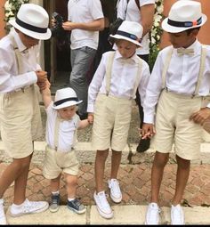 a group of young boys wearing white hats and suspenders