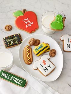 some cookies are on a white plate and one is decorated with the name of an apple