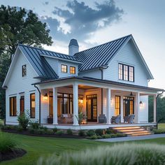 a large white house with lots of windows on it's roof and front porch