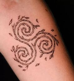 a tattoo with three spirals on the arm