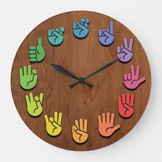 a wooden clock with colorful hand prints on it