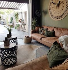 a living room filled with furniture and a large clock on the wall above it's windows