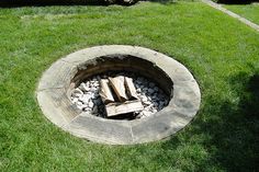 a fire pit in the middle of some grass