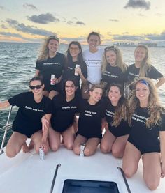 a group of women sitting on the back of a boat posing for a photo together