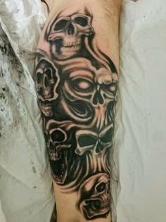 a man with a tattoo on his arm that has three skulls and one skull in the middle