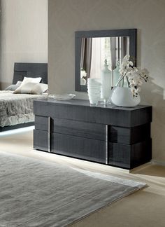 a bedroom with a bed, dresser and mirror