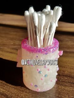 there are toothbrushes in the cup with pink and white flakes on it