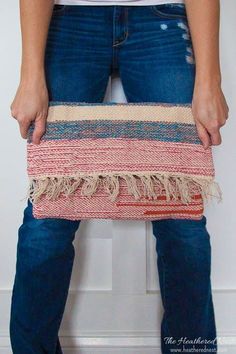 a woman holding a multicolored striped purse