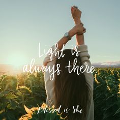 a woman standing in a field with her hands up to the sky and text that reads, light is always there