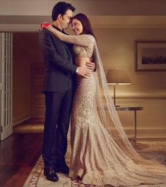 a man and woman standing next to each other in front of a doorway wearing wedding gowns