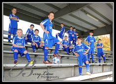 a group of young boys in blue soccer uniforms standing on bleachers next to each other