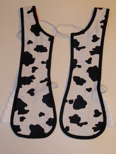 two oven mitts with black and white cow print on them, one is open