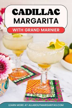 two margaritas sitting on top of a table next to flowers