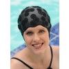 a woman wearing a black swim cap near a swimming pool with blue water in the background