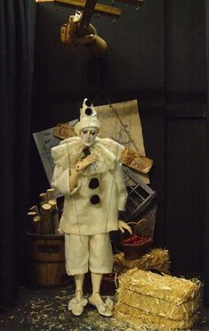 a statue of a clown is posed in front of a black background with gold foil