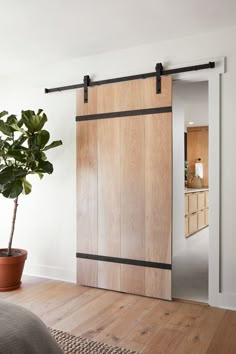 an open sliding door in a bedroom with a potted plant on the floor next to it