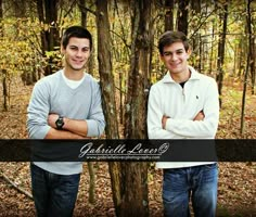 two young men standing next to each other in the woods with their arms crossed and looking at the camera